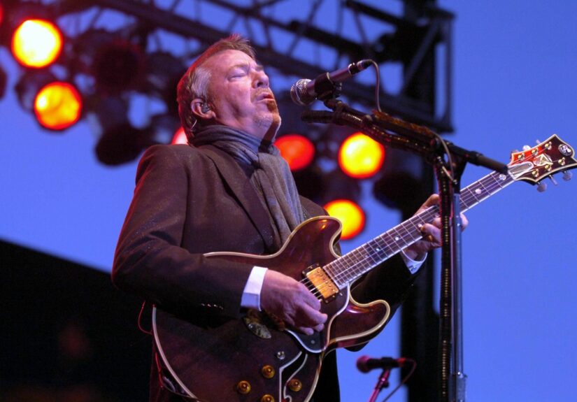 Boz Scaggs playing guitar and singing into microphone