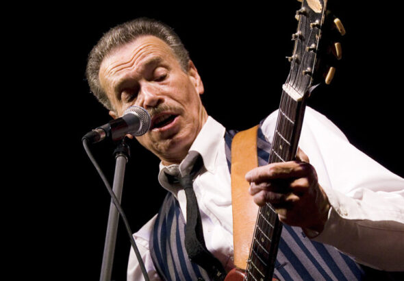 Morgan Davis close up playing guitar and singing