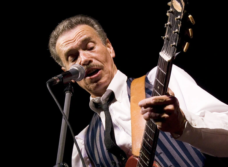 Morgan Davis close up playing guitar and singing